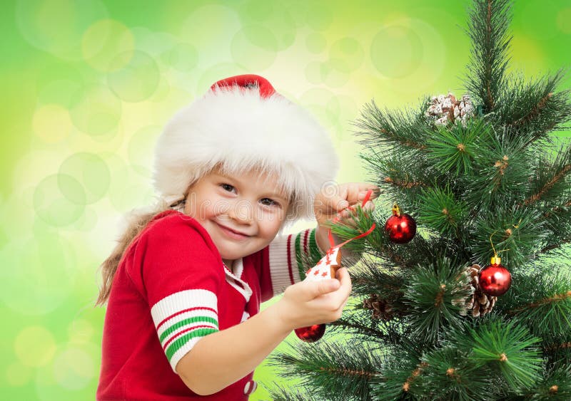 Pretty preschool girl decorating Christmas tree
