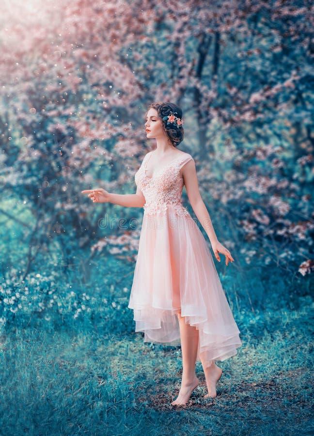 Pretty slender girl with braided dark hair in a delicate elegant peach dress, a fairy-tale princess in a frozen