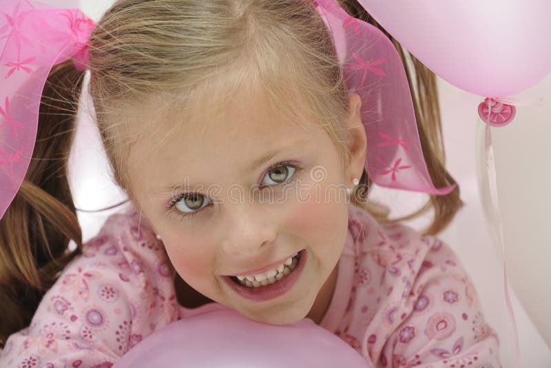 Pretty smiling and playing with pink balloons