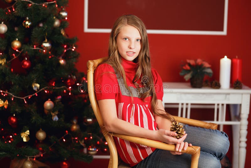 pretty smiling teen girl with long hair in interior with Christmas decorations