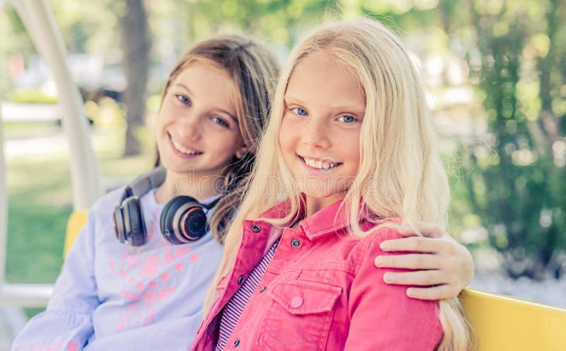 Pretty smiling teenage girls sit hugging together royalty free stock photos Pretty smiling teenage girls sit hugging together royalty free stock photos