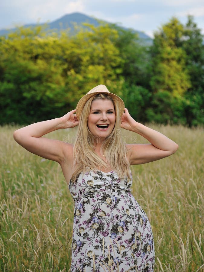 Pretty summer woman on wheat field in countryside