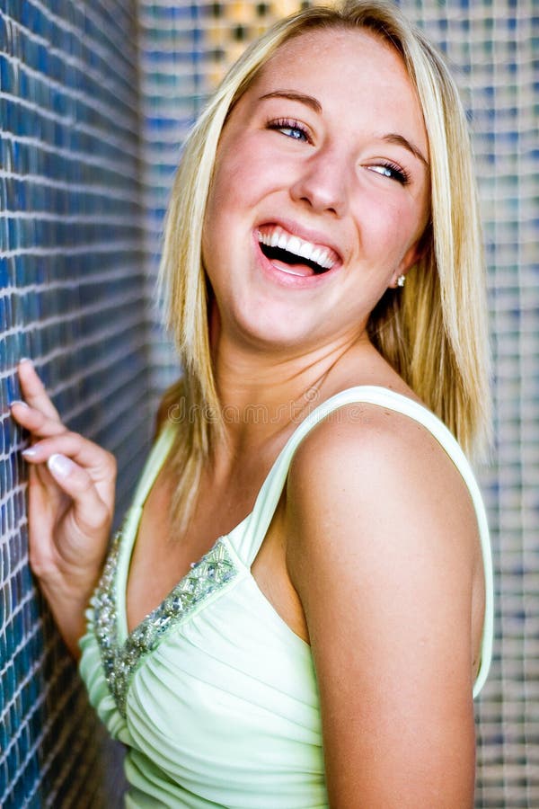 Pretty teen girl with blonde hair laughing royalty free stock photography