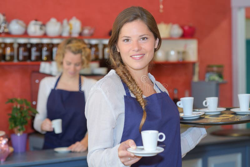 Pretty waitresses behind counter working at coffee shop