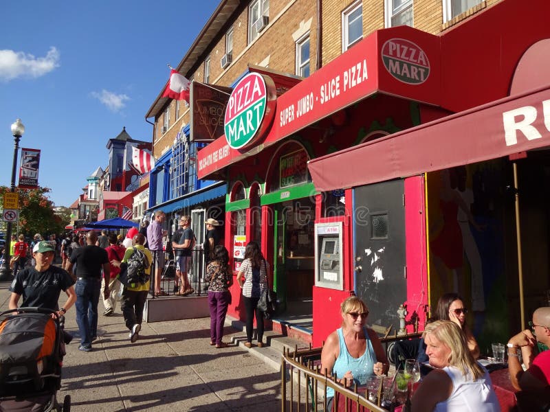 Photo of people and colorful buildings in adams morgan in washington dc on 9/13/15 on adams morgan day. This diverse neighborhood has many restaurants and retail stores. Adams morgan day is big party or festival featuring music, food and arts and crafts. Photo of people and colorful buildings in adams morgan in washington dc on 9/13/15 on adams morgan day. This diverse neighborhood has many restaurants and retail stores. Adams morgan day is big party or festival featuring music, food and arts and crafts.