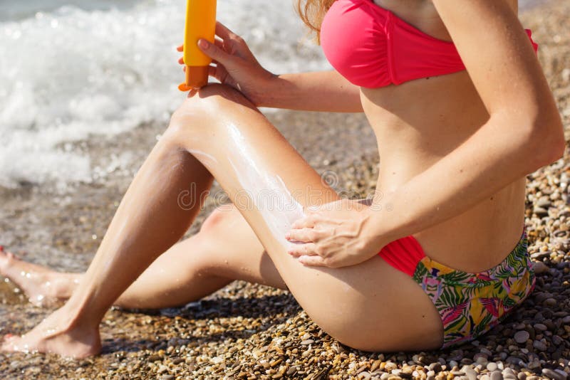 Pretty woman applying sunscreen lotion on her legs royalty free stock photo Pretty woman applying sunscreen lotion on her legs royalty free stock photo