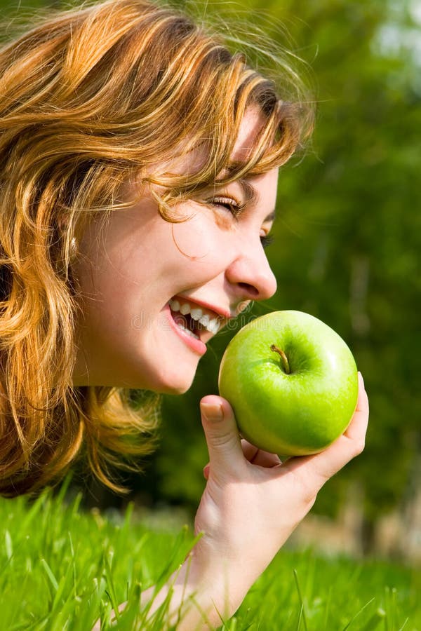 Pretty woman eating green apple