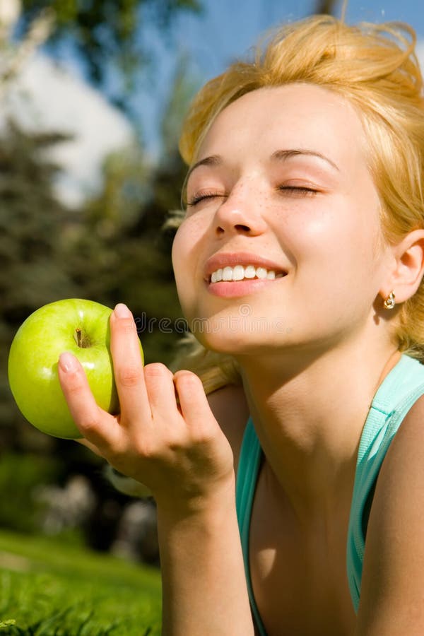 Pretty woman eating green apple