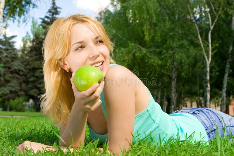 Pretty woman eating green apple