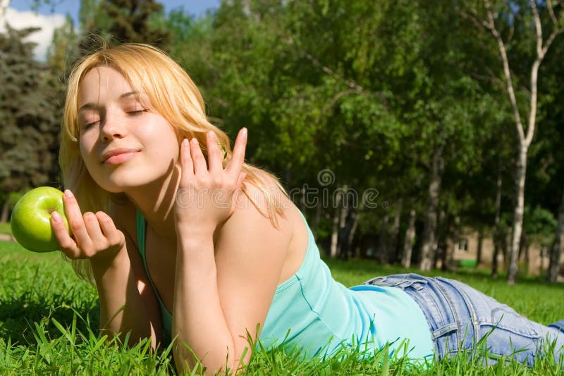 Pretty woman eating green apple