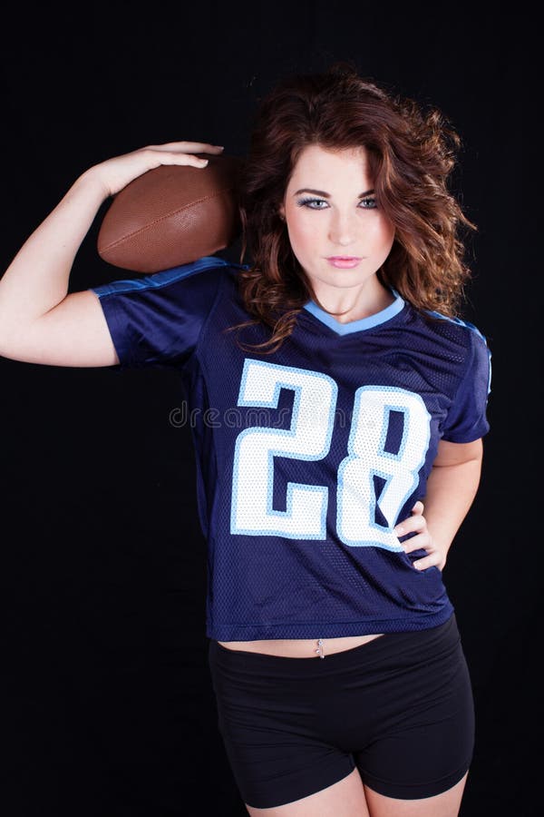 Pretty woman with football in a sports jersey