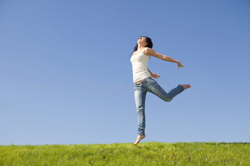 Pretty woman jumping on green grass