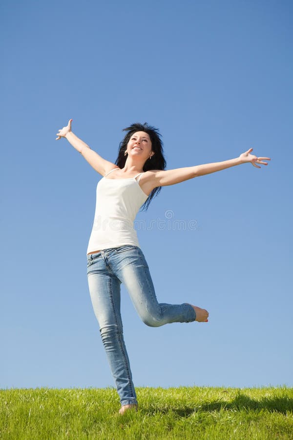 Pretty woman jumping on green grass