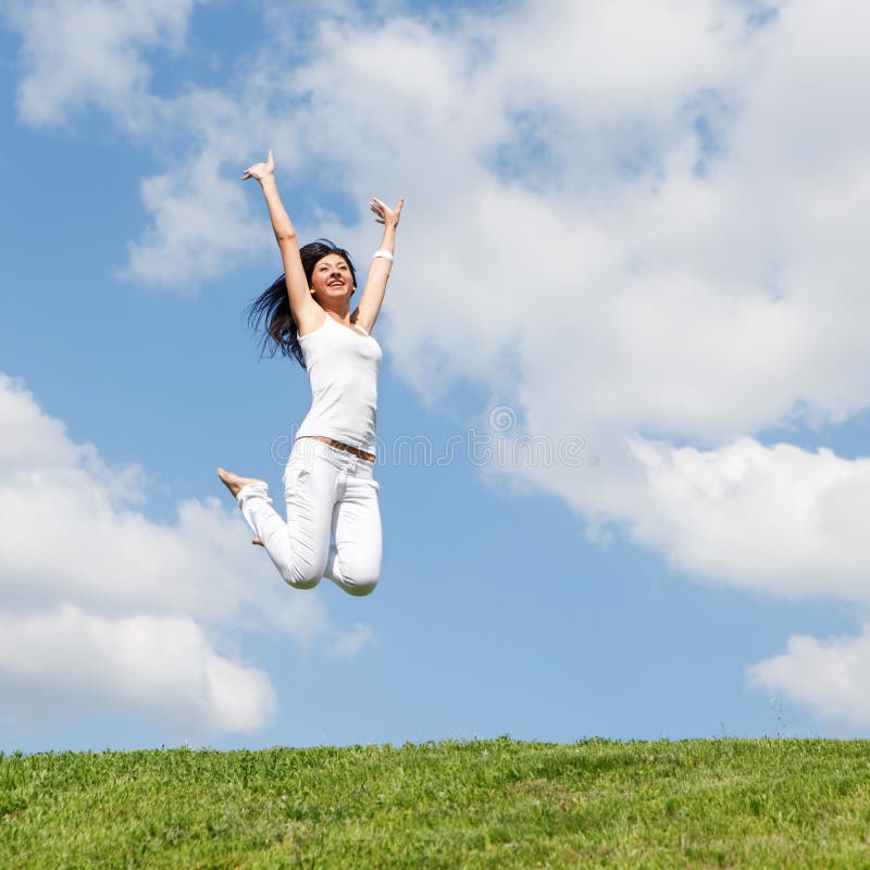 Pretty woman jumping on green grass