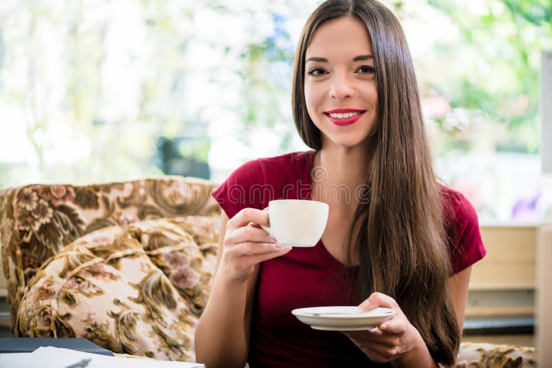 Pretty woman with a lovely smile drinking coffee