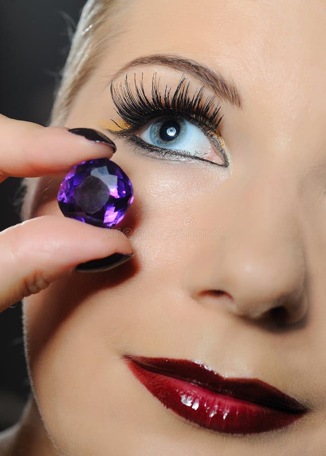 Pretty woman with make-up and violet jewel stone