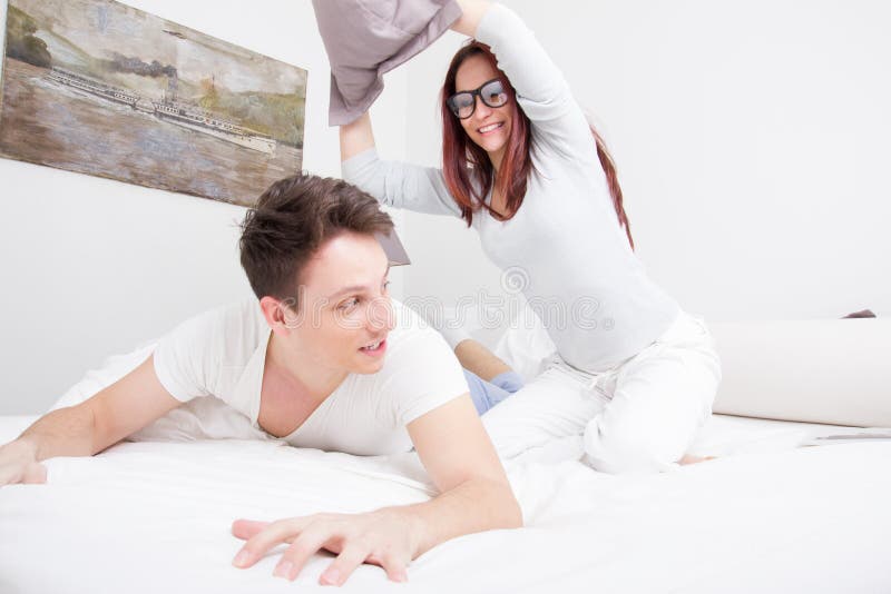 Pretty Woman in Pajamas Hitting Man with Pillow Stock Photo - Image of ...