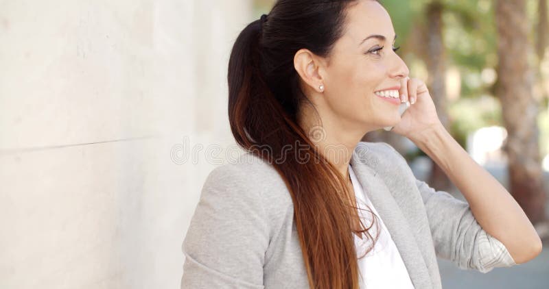Pretty woman smiling as she chats on a mobile