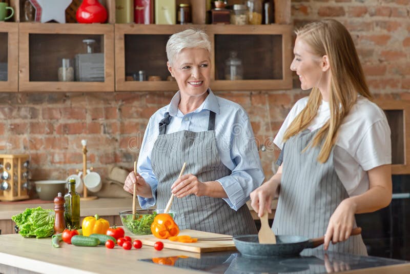 Pretty Woman Talking To Her Mom while Making Dinner Together Stock ...