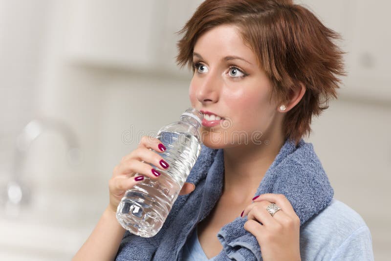 Pretty Woman with Towel Drinking From Water Bottle