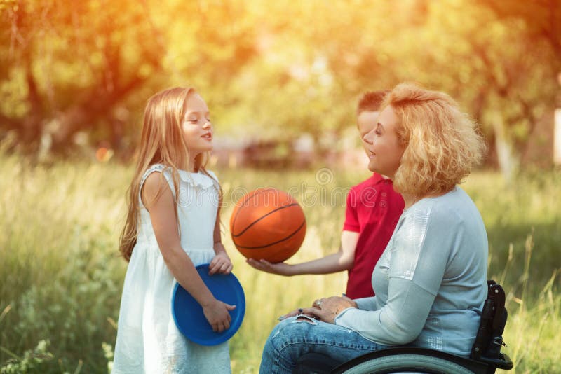 Pretty woman in wheelchair talks with children royalty free stock photos Pretty woman in wheelchair talks with children royalty free stock photos