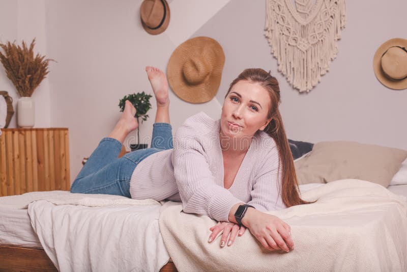Pretty 25 year old Girl At Home On Bed In Sweater And Jeans Stock Image pretty-25-year-old-girl-at-home-on-bed-in-sweater-and-jeans-stock-image
