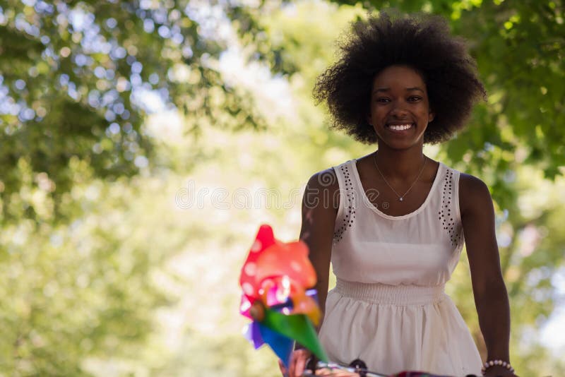 Pretty young african american woman riding a bike in forest stock photo Pretty young african american woman riding a bike in forest stock photo