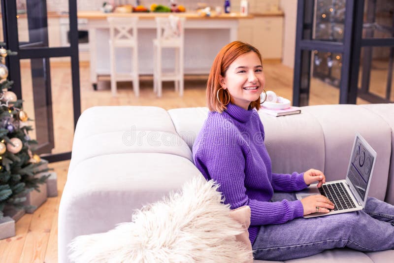 Pretty young beaming girl in a violet sweater smiling brightly royalty free stock photo Pretty young beaming girl in a violet sweater smiling brightly royalty free stock photo