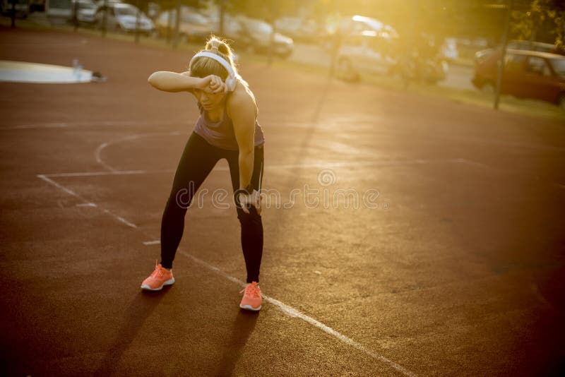 Pretty young female resting after an active fitness training while standing on the playground royalty free stock photos Pretty young female resting after an active fitness training while standing on the playground royalty free stock photos