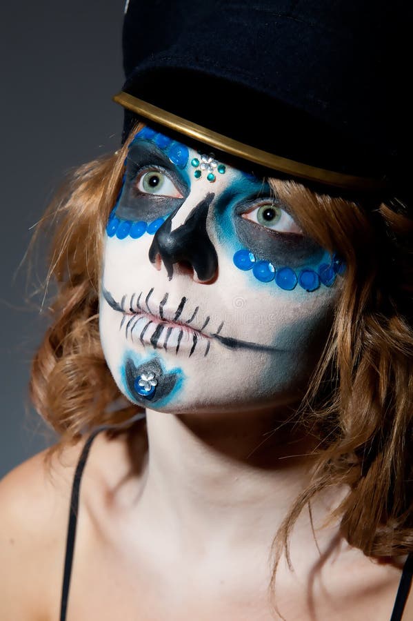 Pretty young female in sugar skull make up and hat