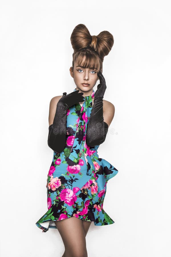 Pretty young girl beauty portrait. Elegant Fashion Glamorous teen Model wearing black Glamour Gloves and floral dress. Bow Hairstyle and Make-up. Spring fashion concept