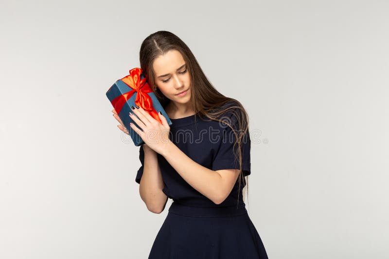 Pretty young girl wearing dark dress holding gift box royalty free stock photography Pretty young girl wearing dark dress holding gift box royalty free stock photography