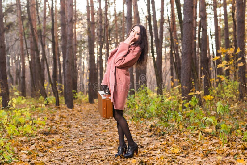 Pretty young woman in autumn park posing with suitcase royalty free stock photos Pretty young woman in autumn park posing with suitcase royalty free stock photos
