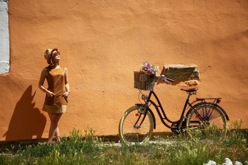 Pretty young woman with bicycle in the park