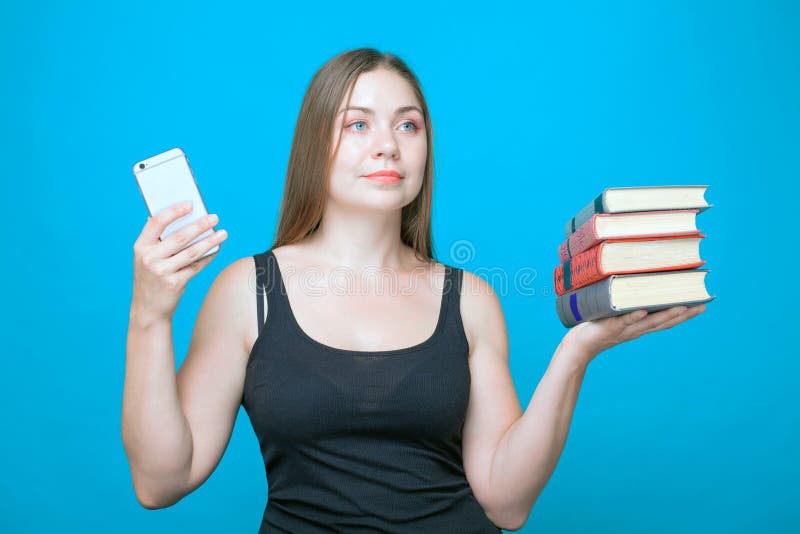 Pretty young woman with the books in the hands and mobile phone