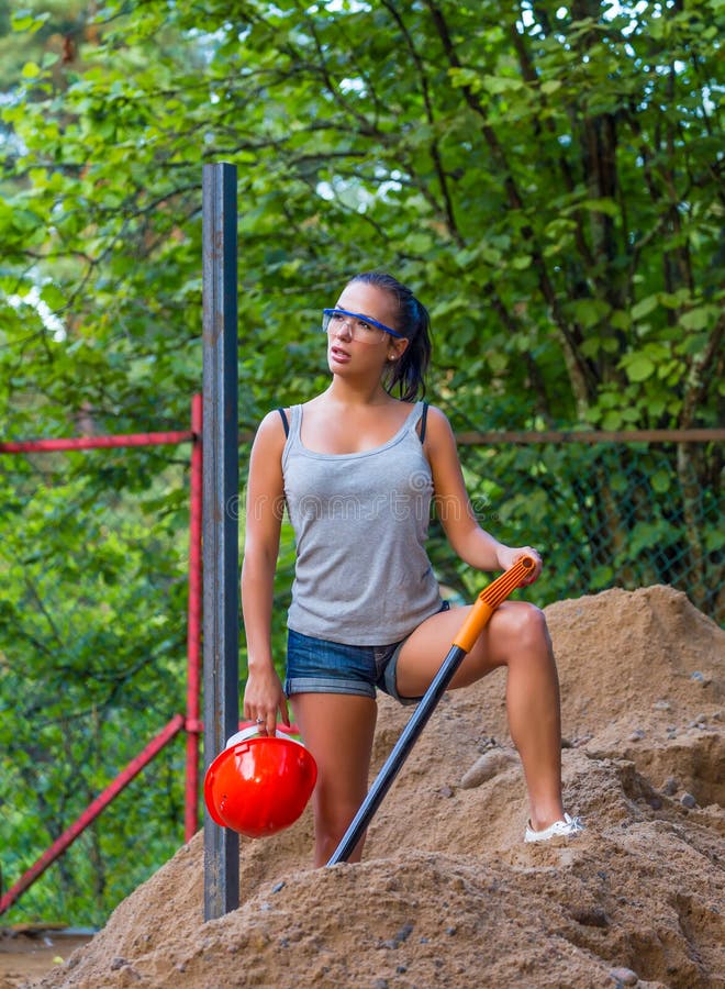 Pretty young woman builder digging