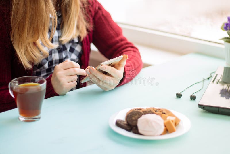 Pretty Young woman at cafe drinking and using mobile phone in sunday morning royalty free stock image Pretty Young woman at cafe drinking and using mobile phone in sunday morning royalty free stock image