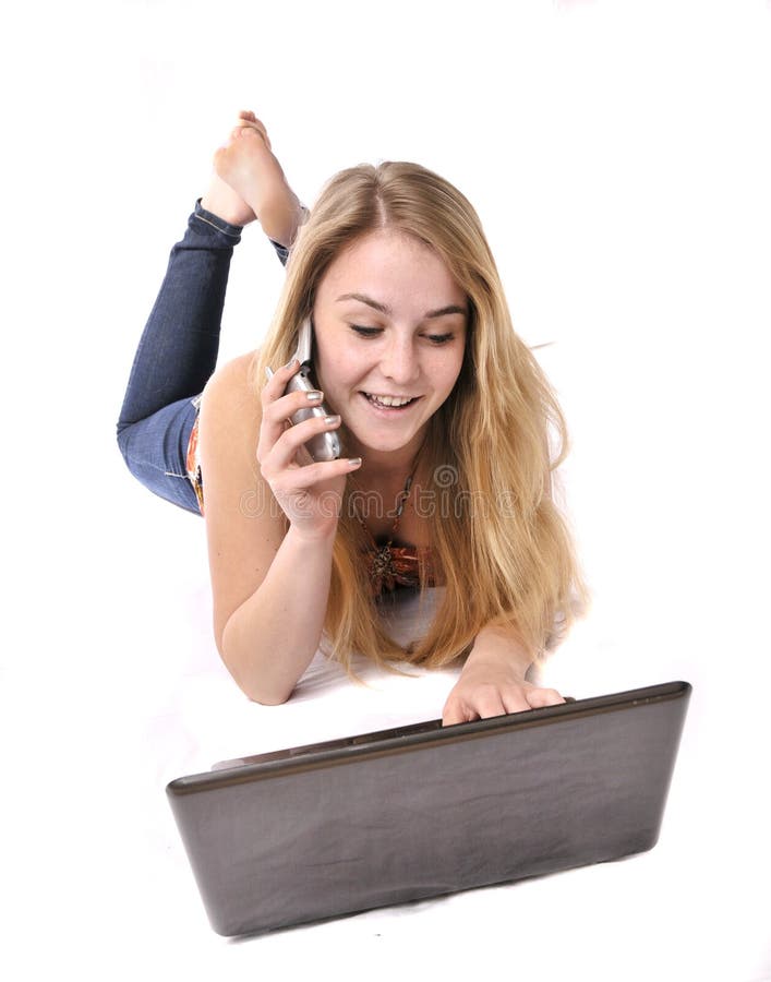 Pretty young woman on cell phone at computer