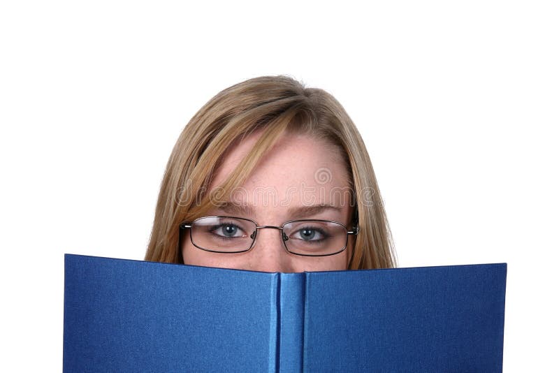 Pretty young woman peeking over top of book