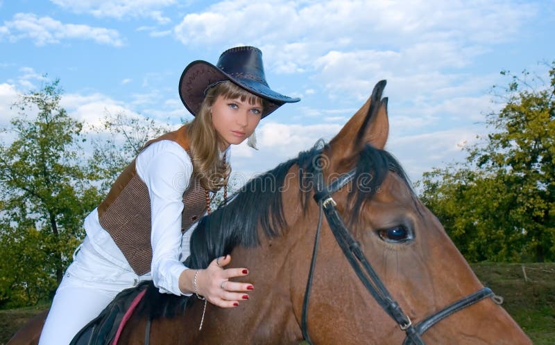 Pretty young woman riding horse.