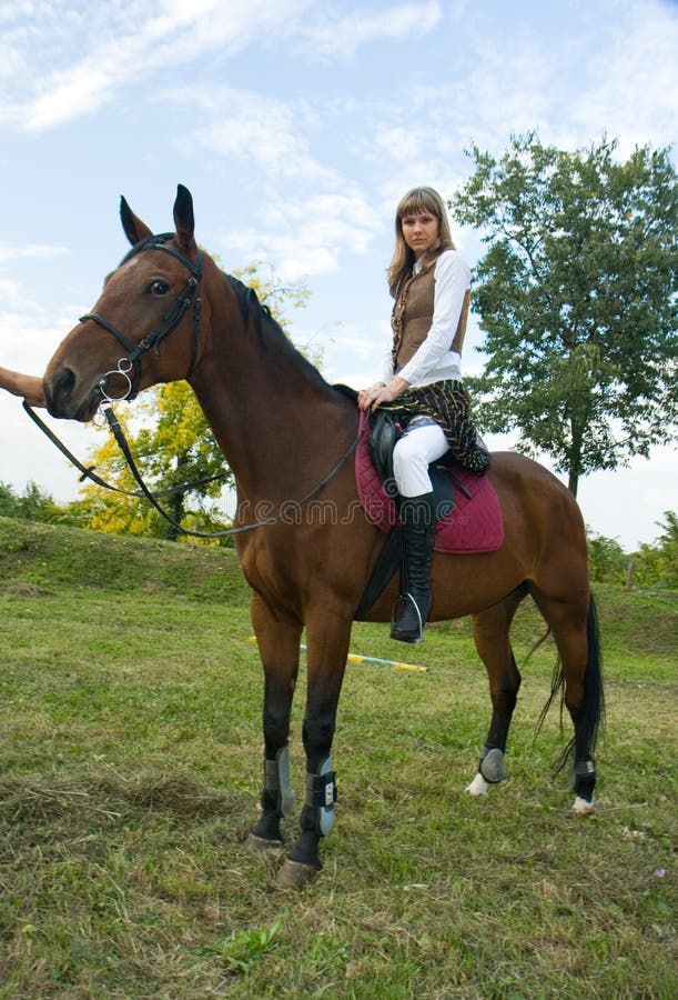 Pretty young woman riding horse.