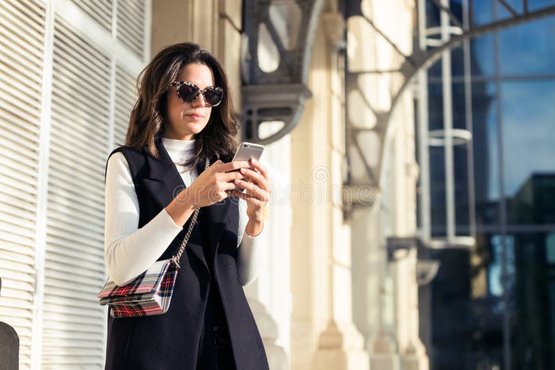 Pretty Young Woman Using Her Mobile Phone While Standing In The Street ...