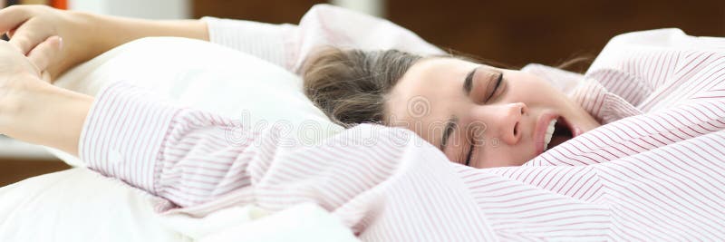 Pretty young woman wakes up in morning and yawns. stock photo Pretty young woman wakes up in morning and yawns. stock photo