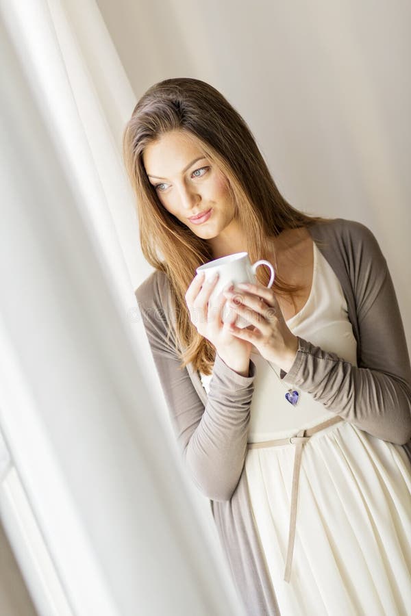 Pretty young woman by the window royalty free stock photo Pretty young woman by the window royalty free stock photo