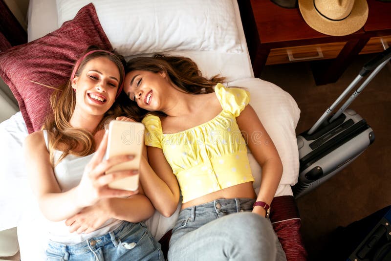 Pretty young women taking a selfie on the bed