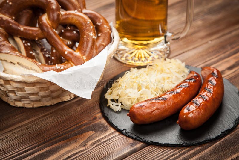 Pretzels, Bratwurst and Sauerkraut on Wooden Table Stock Image - Image ...