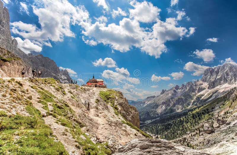 Preuss Refuge and trekkers at the foot of the Vajolet Towers. As seen from the trekking trail from Vajolet refuge to Principe pass royalty free stock photography Preuss Refuge and trekkers at the foot of the Vajolet Towers. As seen from the trekking trail from Vajolet refuge to Principe pass royalty free stock photography