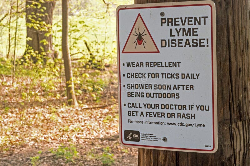 Centers for Disease Control and Prevention prevent lyme disease from deer ticks warning sign on trail in forest nature preserve, upstate rural New York