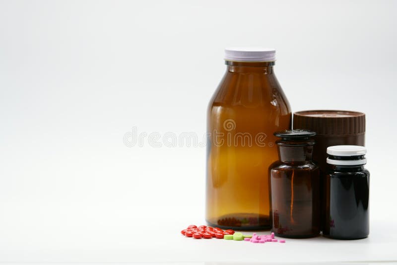 Preventivpillerar och bärnstenflaskor med locket royaltyfri bild Preventivpillerar och bärnstenflaskor med locket royaltyfri bild