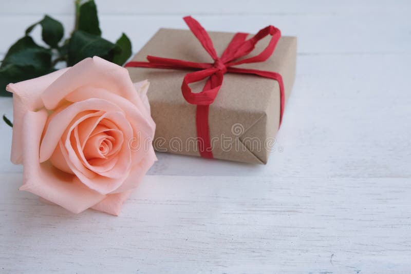 Prezenta pudełko na białej drewnianej podłodze z piękno miękkiej części mleka menchii różą Valentine& x27; s dnia tła pojęcie obrazy stock Prezenta pudełko na białej drewnianej podłodze z piękno miękkiej części mleka menchii różą Valentine& x27; s dnia tła pojęcie obrazy stock